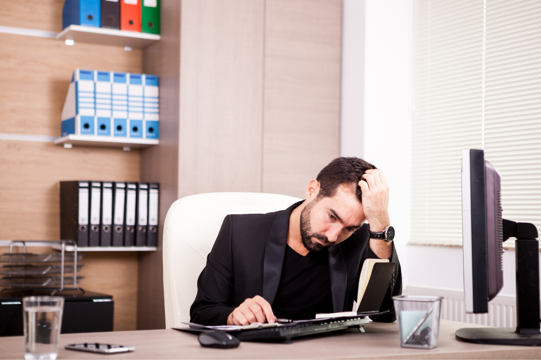 Business owner feeling overwhelmed by paperwork and administrative challenges during the business setup process