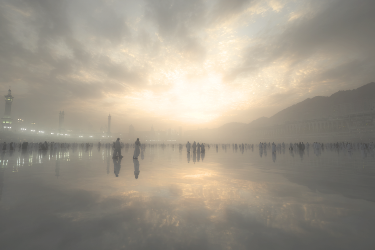 Pilgrims gathered in Makkah at dawn beneath a glowing cloudy sky during the sacred days of Dhul Hijjah.